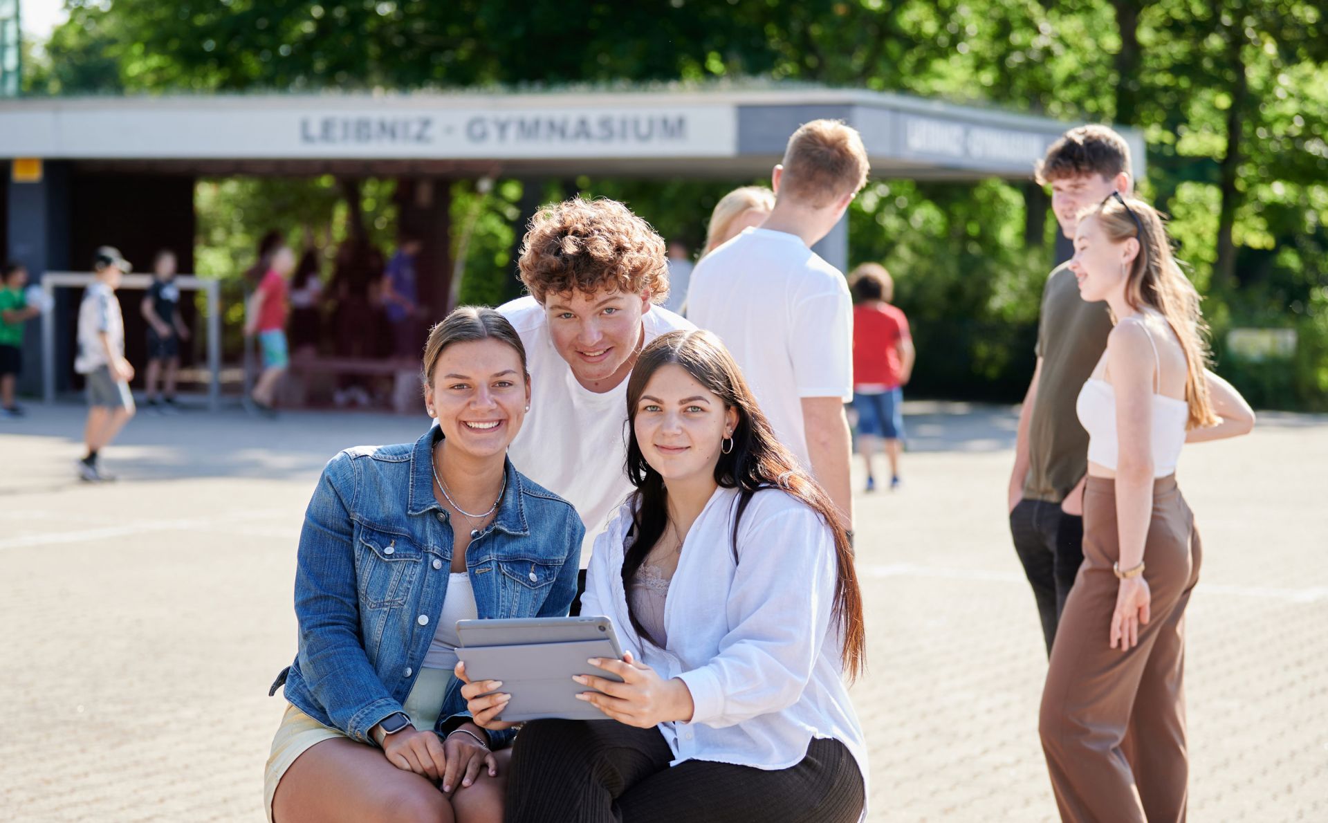 Drei Schüler*innen auf dem Pausenhof des Leibniz-Gymnasiums